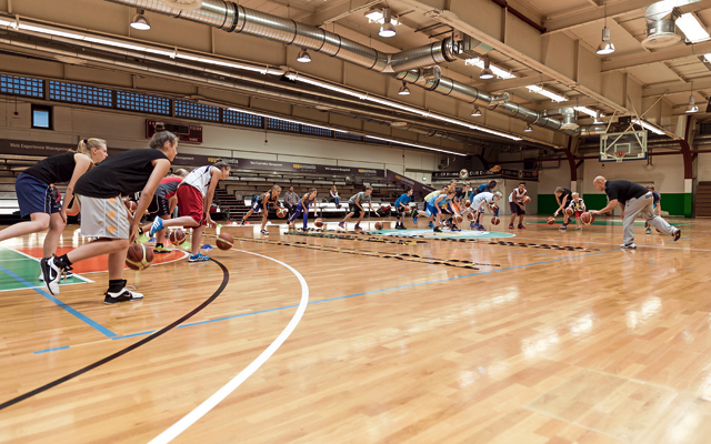 Basketballer dribbeln in einer Halle.
