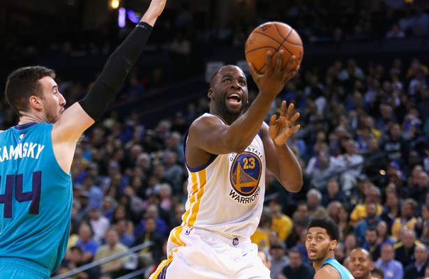 Draymond Green von den Golden State Warriors legt den Ball gegen die Charlotte Hornets in den Korb.