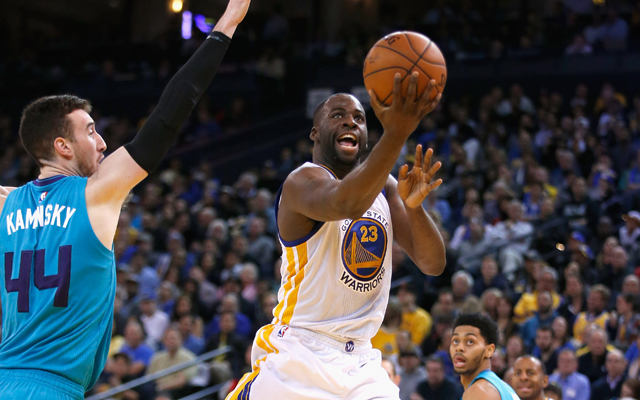 Draymond Green von den Golden State Warriors legt den Ball gegen die Charlotte Hornets in den Korb.