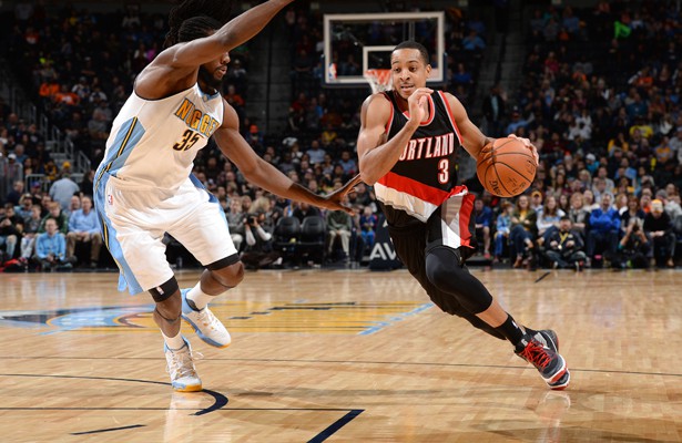 CJ McCollum von den Portland Trail Blazers dribbelt mit Ball an seinem Gegenspieler von den Denver Nuggets vorbei.