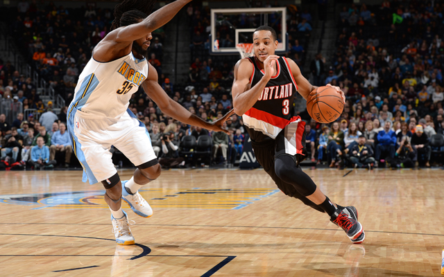 CJ McCollum von den Portland Trail Blazers dribbelt mit Ball an seinem Gegenspieler von den Denver Nuggets vorbei.