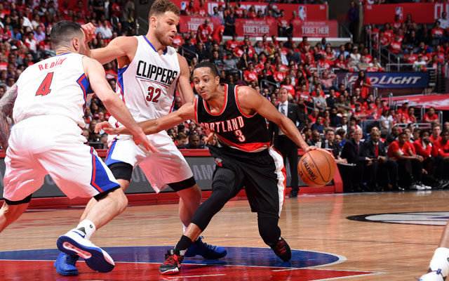 C.J. McCollum von den Portland Trail Blazers dribbelt an Blake Griffin und JJ Redick von den Los Angeles Clippers vorbei.