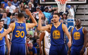 Steph Curry, Klay Thompson und Draymond Green von den Golden State Warriors klatschen sich während eines NBA-Spiels ab.