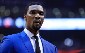 Chris Bosh verfolgt ein Spiel seiner Miami Heat im Anzug an der Seitenlinie.