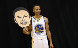 Steph Curry beim Media Day der Golden State Warriors mit einer Maske, die sein Gesicht zeigt.