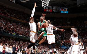 Avery Bradley von den Boston Celtics wird im NBA-Spiel von drei Gegenspielern beim Korbleger gestört.